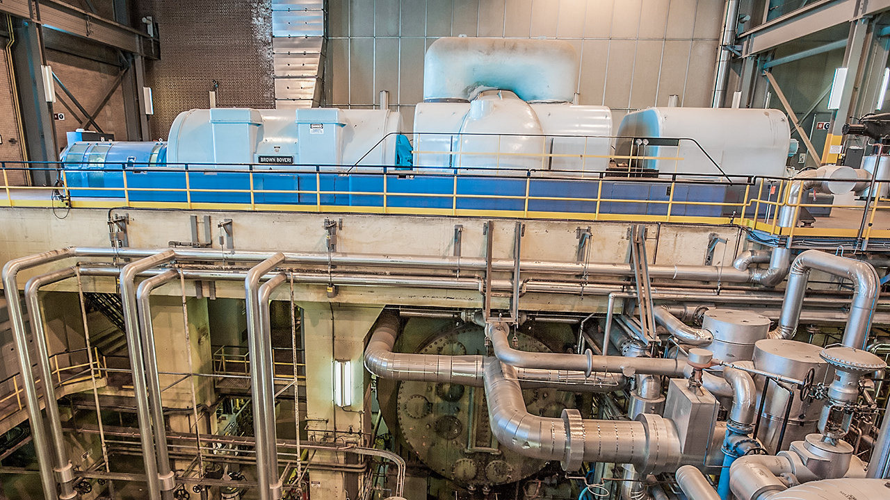 Unit #8 feedwater heaters with associated piping and condenser in foreground and turbine unit on floor above in the background.